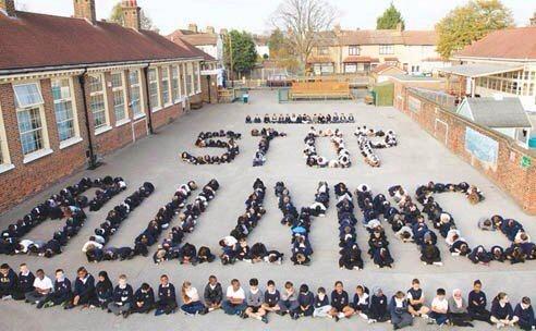 niños haciendo un mosaico que pone stop bullying